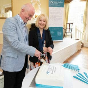 Image of two solicitors cutting a cake at the Bonell and Co event in Stratford’s Town Hall