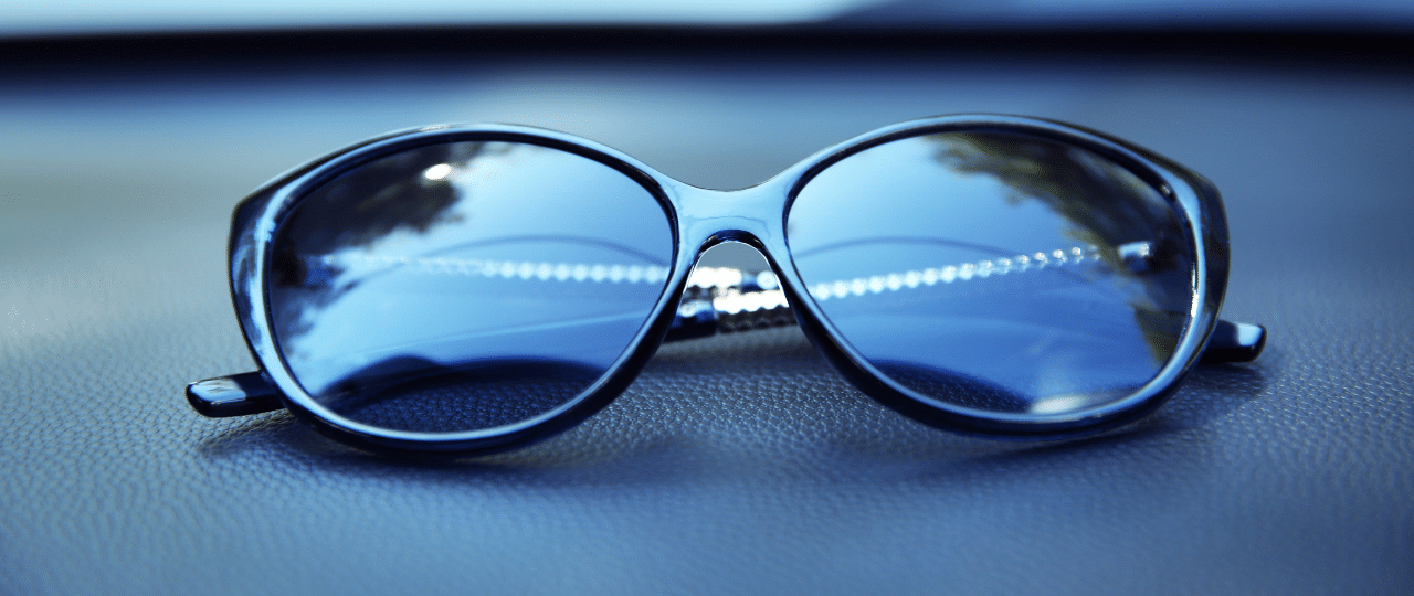 sunglasses resting on the panel of car
