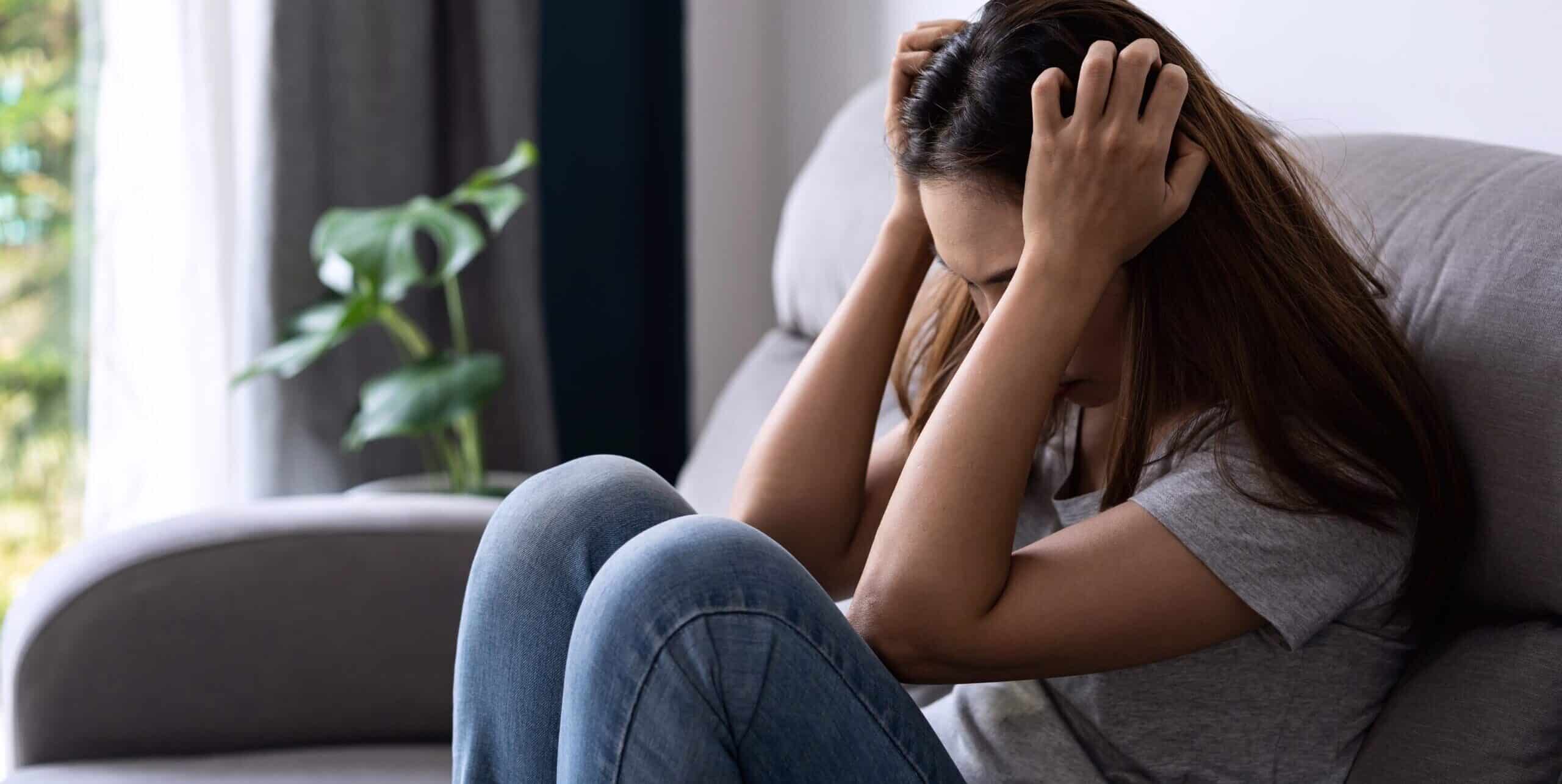 Lonely young asian woman felling depressed and stressed in living room at home, Negative emotion concept
