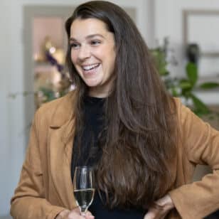 Woman smiling with champagne at Ladies First Networking Lunch