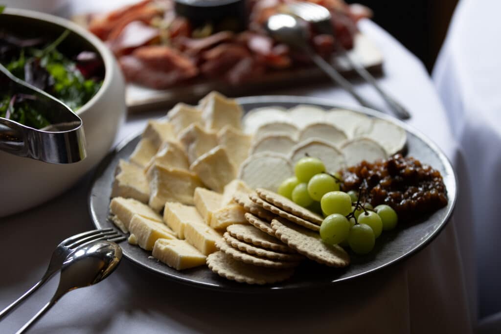 Cheese board with crackers, grapes, and chutney at networking lunch