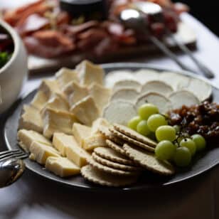 Cheese board with crackers, grapes, and chutney at networking lunch