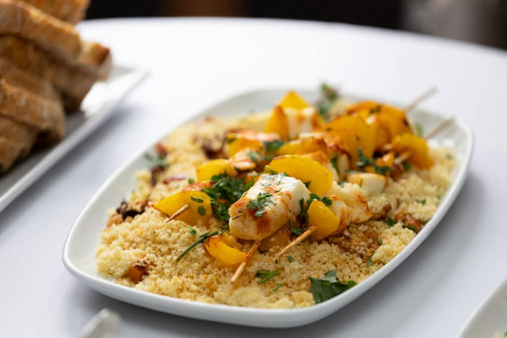 Seafood skewers with couscous and herbs served at a networking lunch.