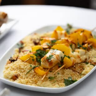 Seafood skewers with couscous and herbs served at a networking lunch.
