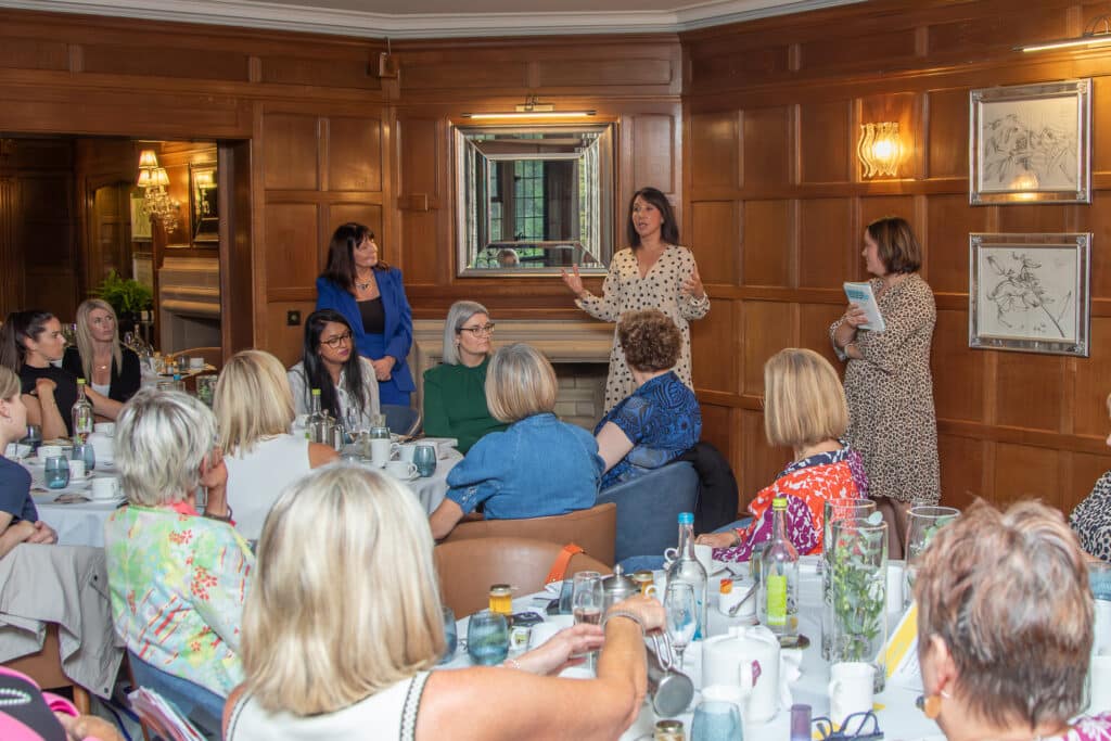 Ladies First networking lunch: speaker addressing group of women seated at tables.