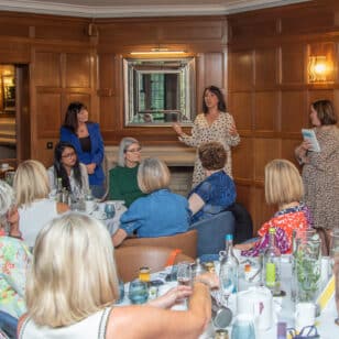 Ladies First networking lunch: speaker addressing group of women seated at tables.