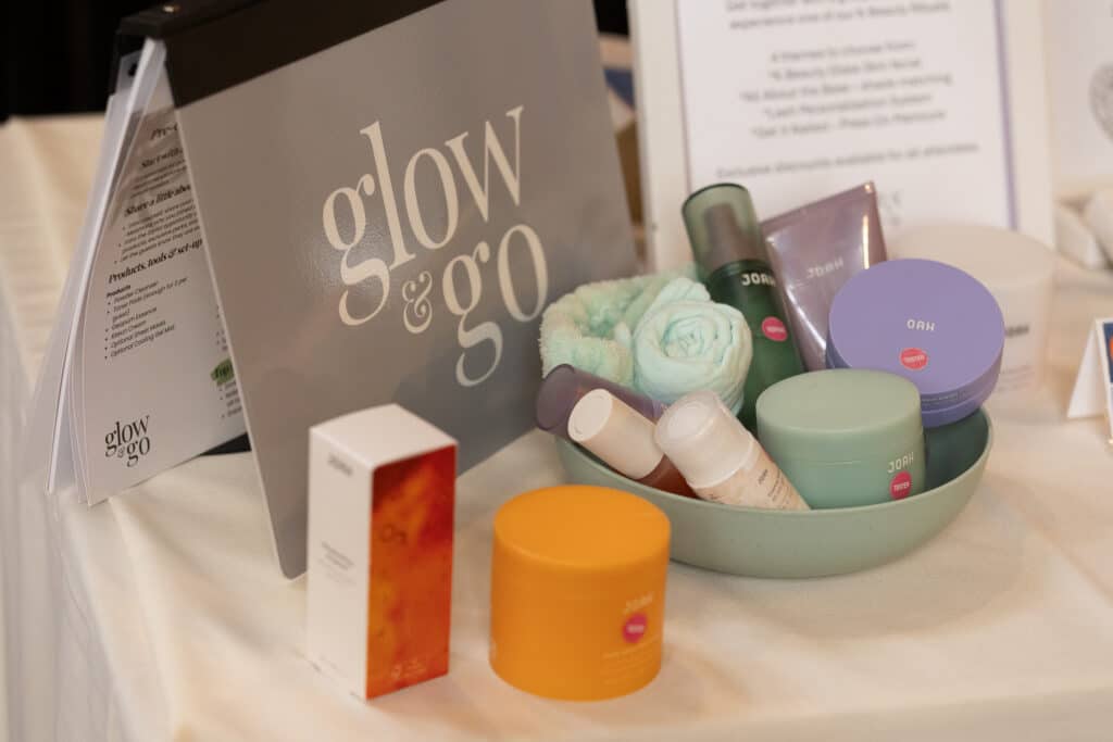 Table with glow & go skincare products in a green bowl, box, and towels