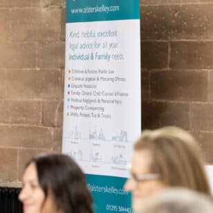 Alsters Kelley solicitors banner with services list at Ladies First Networking event