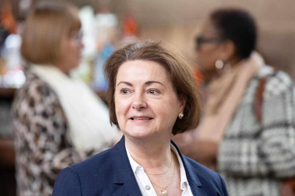 Woman in navy blazer smiling at Ladies First Networking event in February 2026