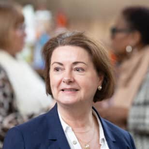 Woman in navy blazer smiling at Ladies First Networking event in February 2026