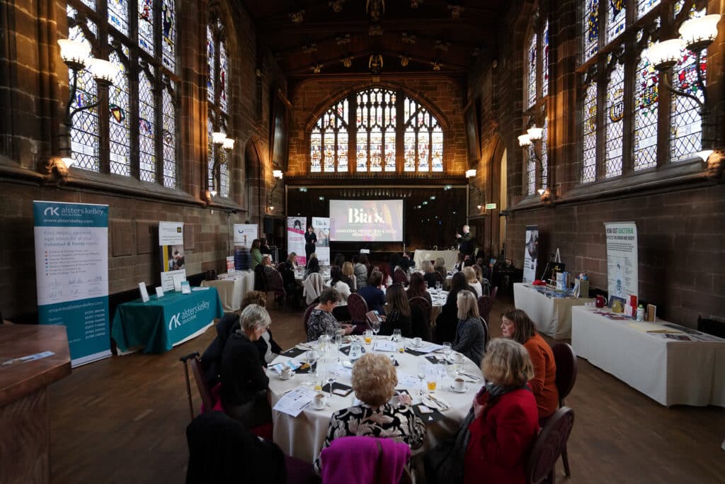 Networking event in a grand hall with Bias presentation on projector screen