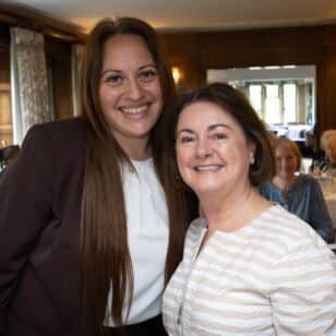 Two women smiling at the Ladies First Lunch event in June 2026