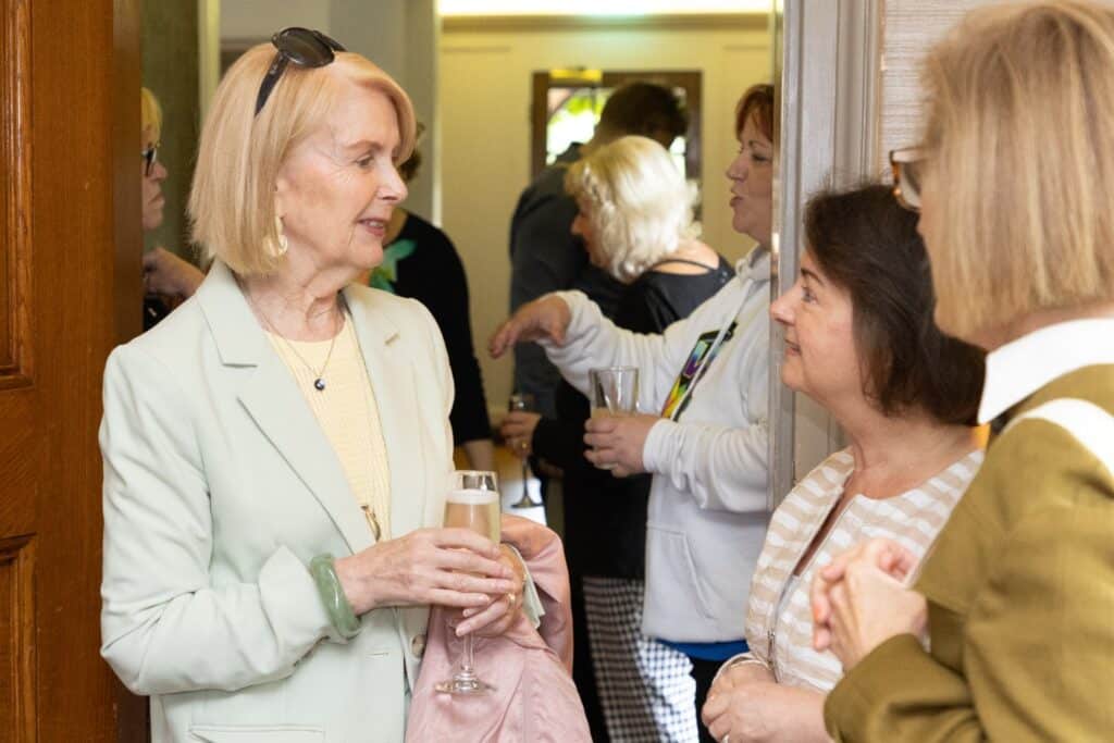 Women at Lafies First Lunch event in June 2026, chatting and holding champagne glasses.